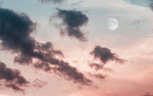 滿月穿過粉紅和青綠色的雲層升起於黃昏。 — 月光 壁紙