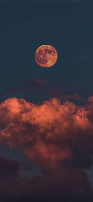 一輪滿月般的橙色月亮照亮了黑暗夜空中的紅色雲層。 — 月光 壁紙