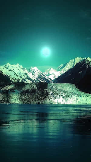 夜晚，在發光的青綠色月亮下的積雪山脈和冰川湖。 — 月光 壁紙