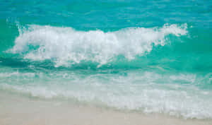 碧綠海浪拍打白色沙灘，泛起白色泡沫。 — 海灘日落 壁紙