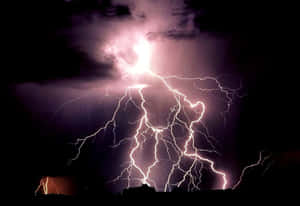 強大的閃電照亮了黑暗山丘上方暴風雨的夜空。 — 閃電 壁紙