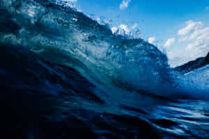 巨大的藍色海浪在明亮的天空下破碎，濺起白色泡沫。 — 海洋 壁紙