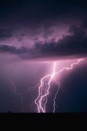 紫色閃電照亮了黑暗景觀上方的暴風雨夜空。 — 閃電麥坤 壁紙