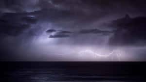 閃電在暴風雨之夜照亮黑暗的海洋。 — 紫色夜空 壁紙