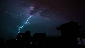 閃電擊中夜晚黑暗的城市屋頂。 — 閃電 壁紙