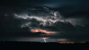 一道強勁的閃電照亮了森林上方暴風雨的夜空。 — 雷龍 壁紙