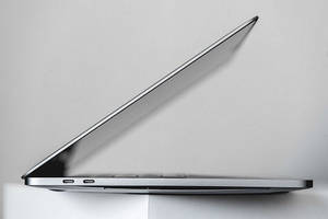 時尚銀色筆記型電腦在白色表面上以角度打開 — MacBook Air 壁紙