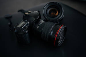 專業 DSLR 相機和鏡頭在工作室燈光下的深色表面上 — 攝影 壁紙