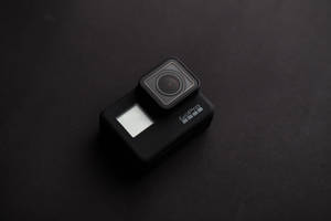 一部黑色GoPro運動相機在深色表面上。 — 攝影 壁紙