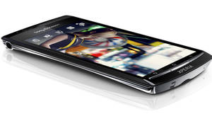 黑色Sony Xperia智慧型手機在白色反光表面上顯示彩色螢幕。 — 三星Galaxy 壁紙
