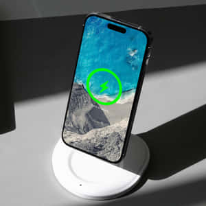 智慧型手機在無線充電器上顯示海洋桌布和 100% 充電狀態。 — 1:1 壁紙