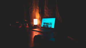 夜晚在黑暗的房間裡發光的筆記型電腦和燈。 — 5120x2880 壁紙