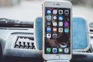 藍色車載支架中的iPhone，屏幕上顯示應用程式圖標 — iPhone 6s Plus 壁紙