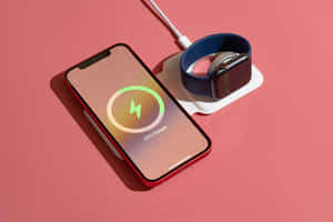 紅色手機和智慧手錶在粉紅色背景下的白色充電座上充電。 — MacBook Air M2 壁紙
