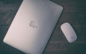 深色木桌上的銀色 MacBook 和滑鼠 — 最佳筆電 壁紙