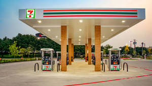 黃昏時分的7 eleven加油站，有油泵和磚柱 — 瓦斯 壁紙