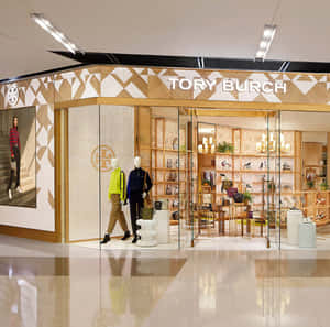 Tory Burch商店，玻璃窗後展示人體模型和手袋。 — 1:1 壁紙