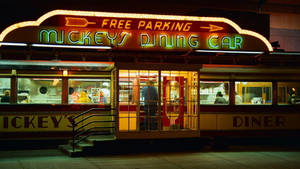 夜晚被霓虹燈招牌照亮的 Mickey's Dining Car 餐廳。 — 米奇妙妙屋 壁紙