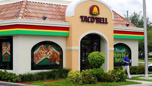 Taco Bell餐廳，有食物海報和行人走過 — 塔可 壁紙
