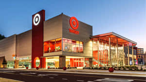 黃昏時的Target零售店，亮著招牌和玻璃外牆。 — 目標 壁紙
