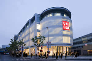 黃昏時分的UNIQLO店鋪，行人穿越馬路。 — 黃昏 壁紙
