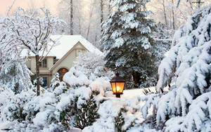 冬季夜晚雪覆蓋的小屋與發光的燈籠 — 溫馨聖誕氛圍 壁紙