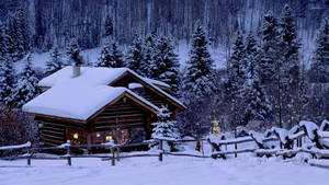 夜晚雪地森林中的舒適小屋，溫暖燈光閃爍。 — 節日 GIF 壁紙