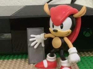 Knuckles the Echidna 玩具人偶在 LEGO 底座上，前方是 Xbox 主機。 — 音速小子 壁紙