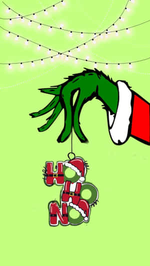戴著聖誕帽的鬼靈精手，拿著一個上方有串燈的「HO HO HO」裝飾品。 — 可愛聖誕節 壁紙