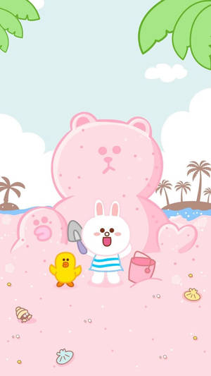 白兔和黃鴨在粉紅色沙子上用一個巨大的粉紅色熊雕塑玩耍。 — LINE FRIENDS 壁紙