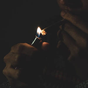 在黑暗中用手點燃大麻煙 — 抽菸 壁紙