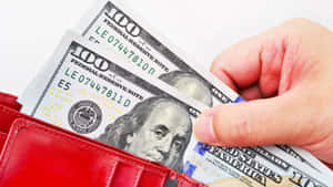 手從紅色錢包中取出現金。 — 金錢 壁紙
