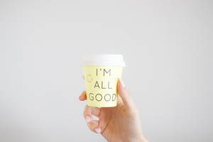 手拿著一個黃色咖啡杯，訊息為I'm All Good。 — 優質 GIF 壁紙