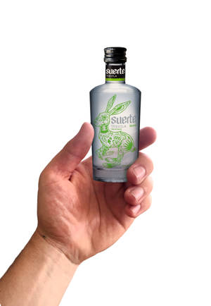 手拿著一個帶有綠色兔子插圖的Suerte Tequila Blanco酒瓶。 — IQOO Pad 壁紙