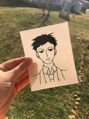 手拿著一幅黑白線條畫，畫中是一個穿著帶領襯衫的動漫男孩在戶外。 — 櫻島麻衣 壁紙