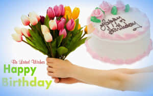 手拿著生日鮮花，旁邊是寫有 'Happy Birthday' 的生日蛋糕。 — 生日祝福 壁紙