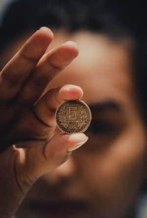 手拿5盧比印度硬幣，背景有模糊的臉。 — 金錢 壁紙