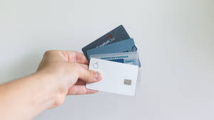手持多張信用卡，包括Apple Card、Capital One和American Express。 — 標誌 壁紙