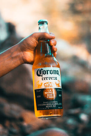 日落時分，戶外一隻手拿著冰涼的Corona啤酒瓶。 — 小米平板 8 Pro 壁紙