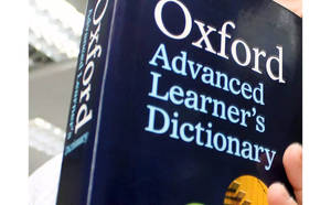 手拿著Oxford Advanced Learner's Dictionary書本。 — 字典 壁紙