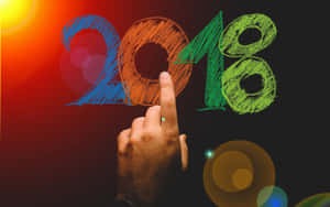手指向用彩色粉筆繪製的2018年，帶有發光的光線。 — 新年快樂 2020 壁紙