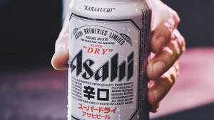 手握住帶有冷凝水珠的冰涼朝日超乾啤酒罐。 — 啤酒 壁紙