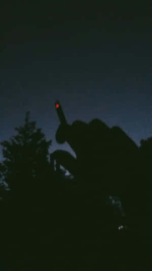 一隻手向上指，帶有紅光，映襯著黑暗的天空。 — 低對比 壁紙