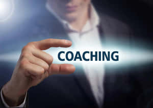 手觸摸螢幕，上面有發光的「coaching」字樣。 — 教練 壁紙