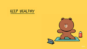 棕色卡通熊在黃色背景上與平板電腦和罐子一起做瑜伽。 — Line Friends 壁紙