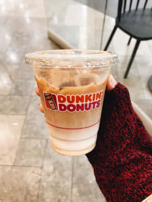 手拿著紅色針織袖子中的Dunkin' Donuts冰咖啡。 — Dunkin Donuts 壁紙