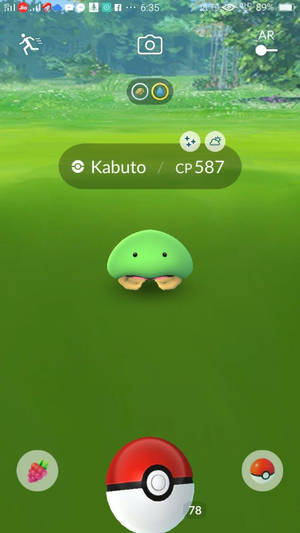 一隻綠色的 Kabuto 寶可夢在 Pokémon GO 遊戲介面中的草地上。 — 電玩遊戲 GIF 壁紙