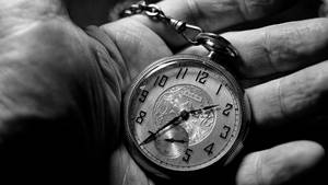 一隻手拿著帶鏈條的復古 Elgin 懷錶的特寫。 — 棕櫚樹 壁紙