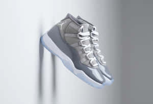 灰色Jordan 11運動鞋懸掛在半空中，背景為灰色牆壁。 — 灰色美學動圖 壁紙