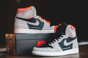 灰黑橙色的 Air Jordan 1 運動鞋放在 Nike 鞋盒上。 — Jordan球鞋 壁紙
